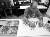 Mike Silvia works on a fresh puzzle at the Veterans Transition House in New Bedford.  Mike daily works on a varity of puzzles and then glues them to cardboard backing and gives some of them to fellow veterans living at the Veterans Transition House.   PHOTO PETER PEREIRA